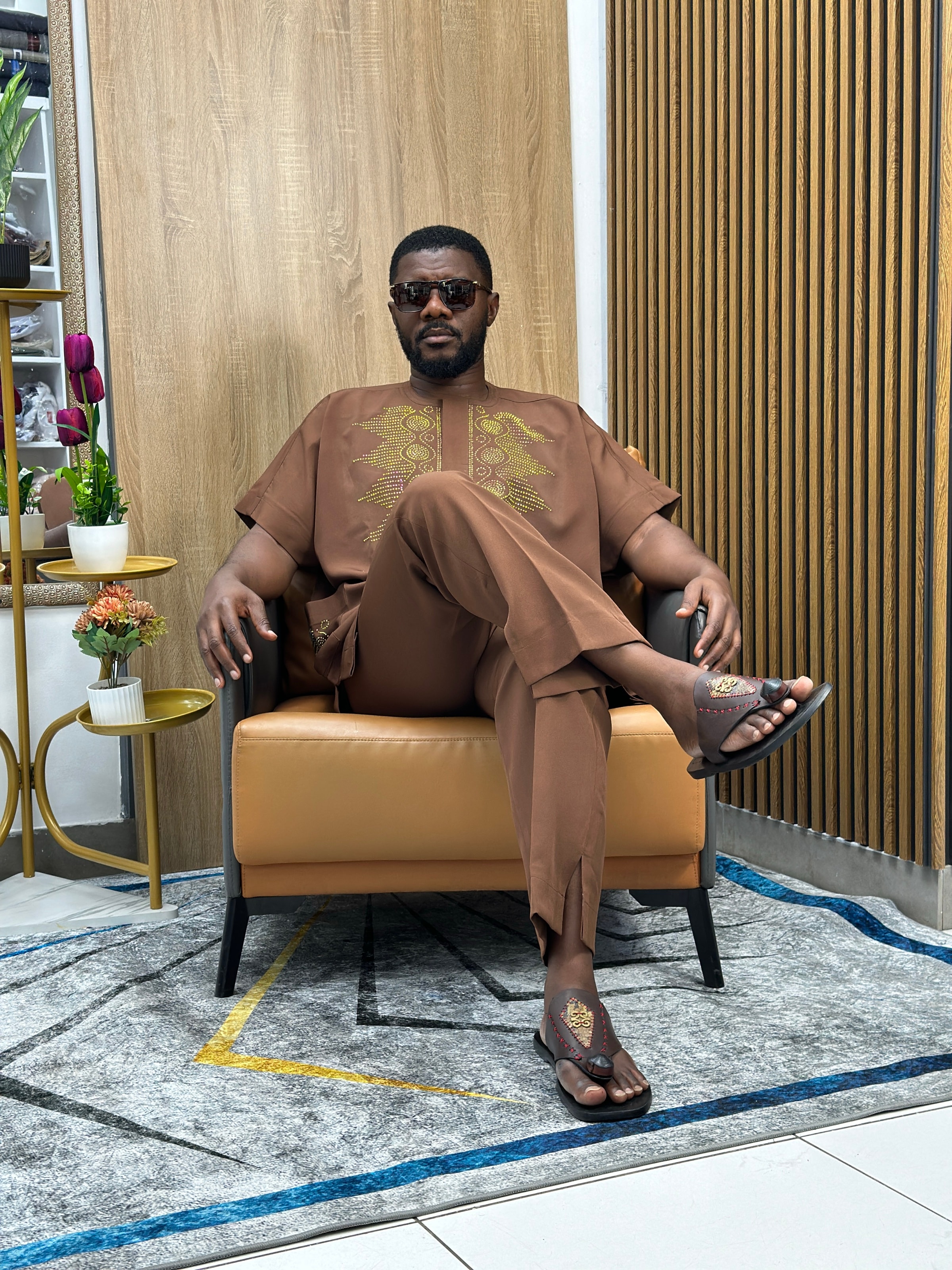 A client seated in a brown embroidered set at the Eddy's Clothing showroom