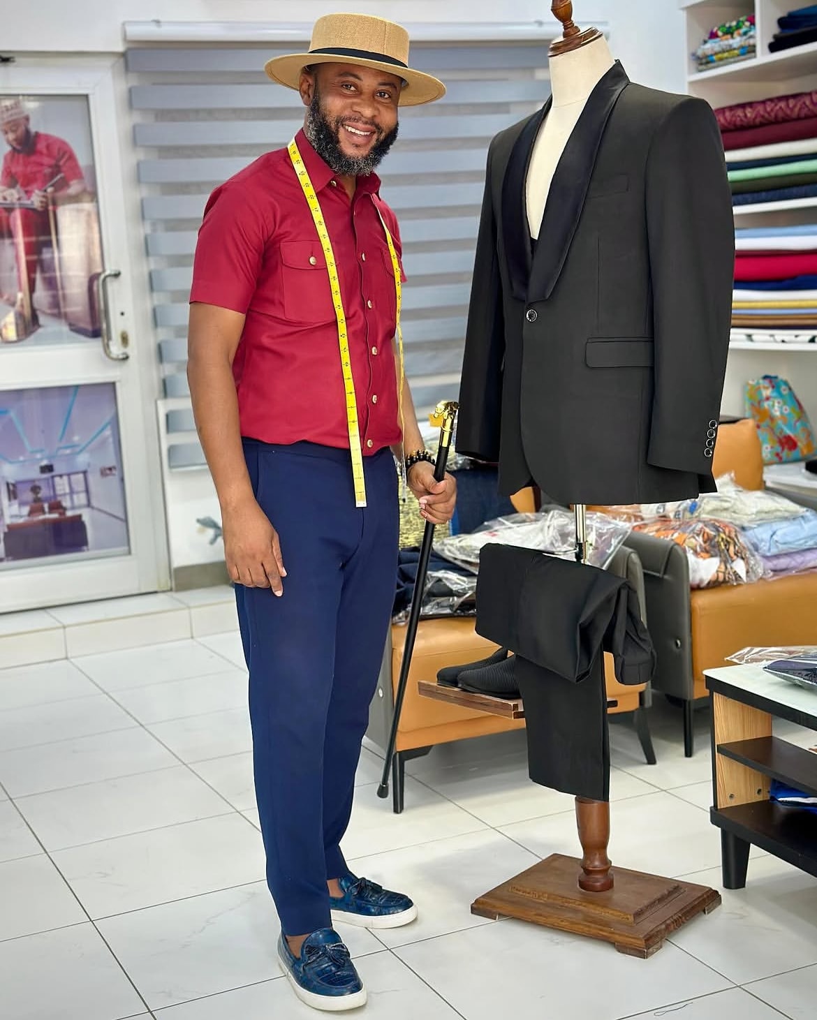The CEO of Eddy's Clothing in the showroom, a tape measure round his neck